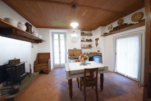 Rustica zona cucina-pranzo nell'appartamento Piano Nobile a Roseto del Drago, Ponte in Valtellina, con tavolo in legno e giardino