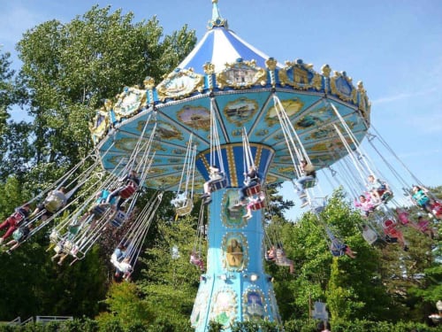 Manège coloré avec baldaquin bleu dans un parc d'attractions près de Beussent, France