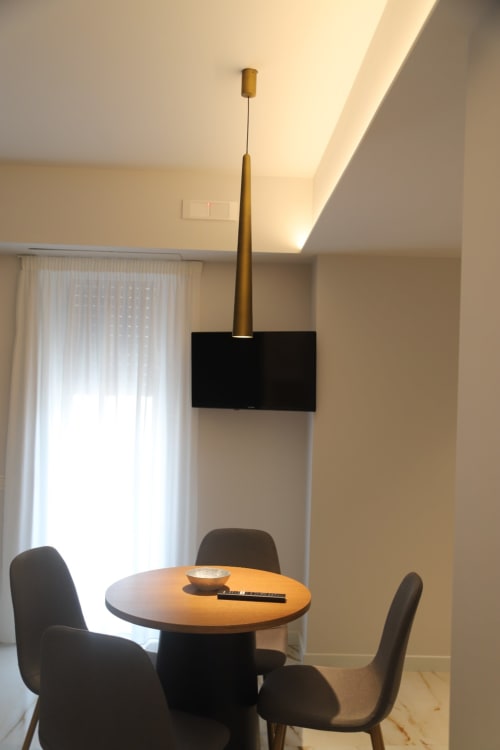 Moderna sala da pranzo nelle Camere di Totonno, Tropea con tavolo rotondo, sedie nere, lampada a sospensione e vista sulla città
