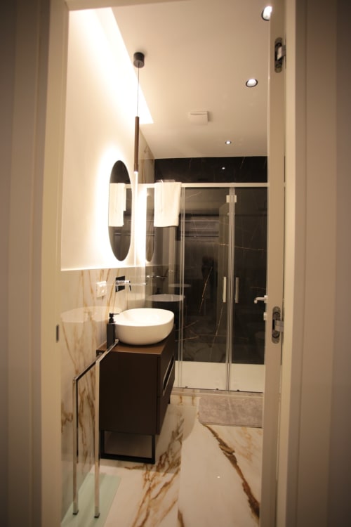 Bagno moderno presso le Rooms di Totonno a Tropea con lavabo freestanding, box doccia nero e dettagli in marmo