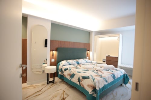 Camera moderna nelle Rooms di Totonno a Tropea con letto rivestito in teal, pavimento in marmo e bagno privato