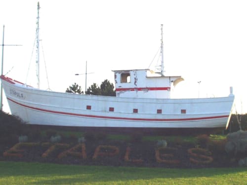 Bateau de pêche échoué à bande rouge et coque blanche aux Gîtes du Clubhouse à Beussent, France