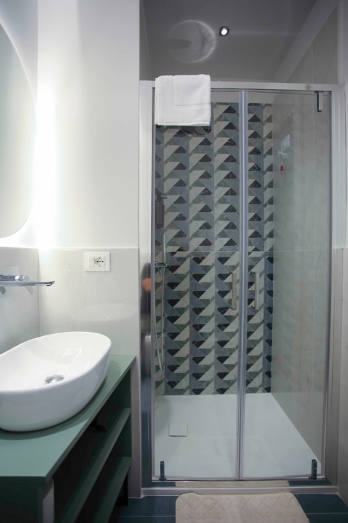 Bagno moderno con doccia a piastrelle geometriche presso le Camere di Totonno, Tropea