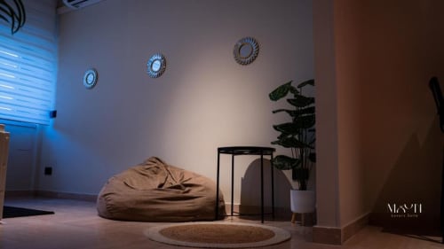 Moderna Deluxe King Room presso Moon Rooms By Celeste a Catania con poltrona pouf, pianta in vaso e decorazioni geometriche alle pareti