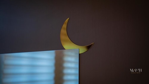 Scultura di luna crescente dorata sopra schermo TV sfocato nella camera d'albergo Moon Rooms By Celeste, Catania