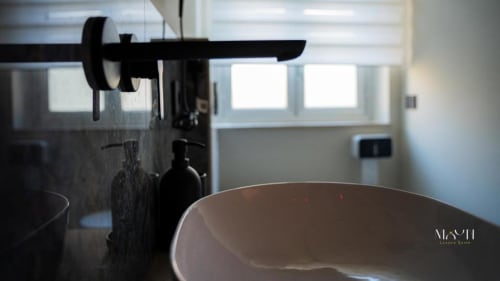 Bagno moderno del B&B di Catania con lavabo elegante, rubinetteria nera e ampie finestre sulla città