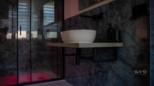 Bagno moderno dell'hotel di Catania con lavabo in ceramica bianca su scaffale in legno e rivestimento in marmo scuro