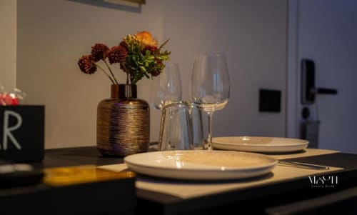 Elegante tavolo da pranzo al Moon Rooms By Celeste con coperto, calici di vino e composizione floreale a Catania