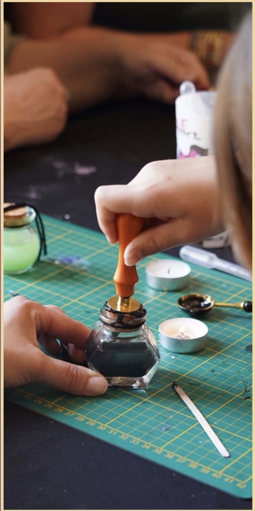 Mains utilisant des outils de calligraphie sur un tapis de découpe à l'atelier artisanal du Domaine de Châlus-Chabrol à Châlus, France