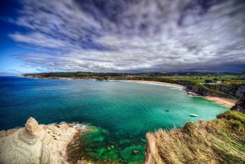 Pristina cala costera con aguas turquesas y playa de arena dorada cerca de Liérganes, España
