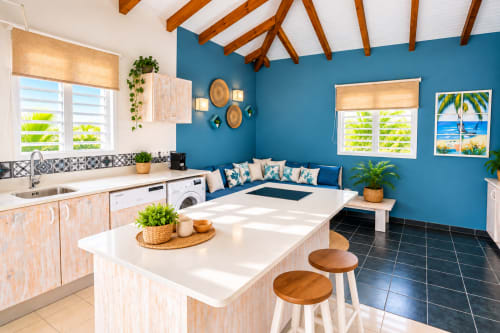 Cuisine de l'appartement Aigue-marine au Le Quetzal B&B, Sainte-Anne avec murs bleus, comptoirs blancs et vue sur la piscine