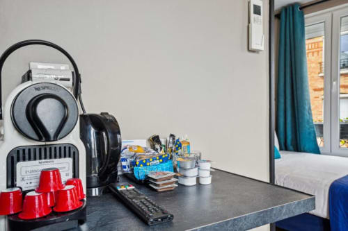 Machine Nespresso, casque audio et équipements sur le bureau du studio de l'hôtel Paris Boulogne