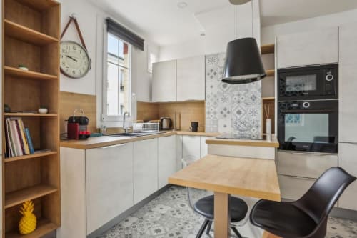 Modern kitchen in Deluxe 1-Bedroom Apartment at Résidence Aurmat, Paris Boulogne, with white cabinetry, wooden accents,