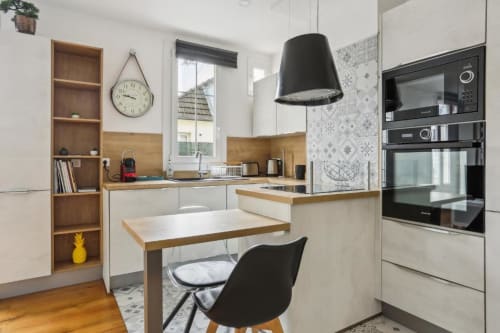 Cuisine-salle à manger moderne de l'appartement Deluxe à la Résidence Aurmat Paris avec finitions bois, suspension noire