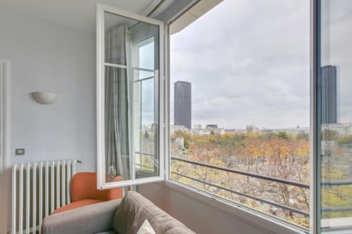 Appartement parisien moderne avec vue sur la ville, chauffage radiateur et feuillage automnal depuis le balcon de la Résidence Aurmat.