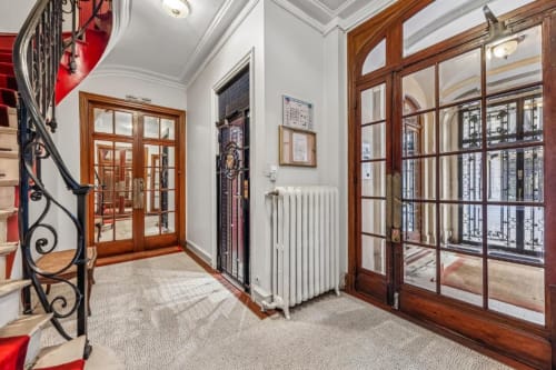 Elegant hallway in Trocadéro Apartment at Résidence Aurmat Paris with wooden doors, white radiator, and classical French