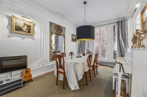 Elegant Parisian dining room in Trocadéro Apartment at Résidence Aurmat with round table, wooden chairs, and modern black
