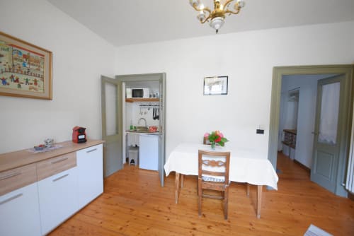 Spazioso soggiorno dell'appartamento a Roseto del Drago B&B con pavimenti in legno, tavolo da pranzo, angolo cottura e arredi classici
