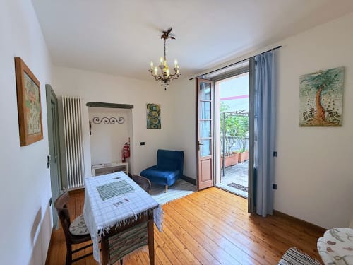 Appartamento La Rosa a Roseto del Drago con parquet, tavolo da pranzo, sedia blu e accesso alla terrazza a Ponte In Valtellina