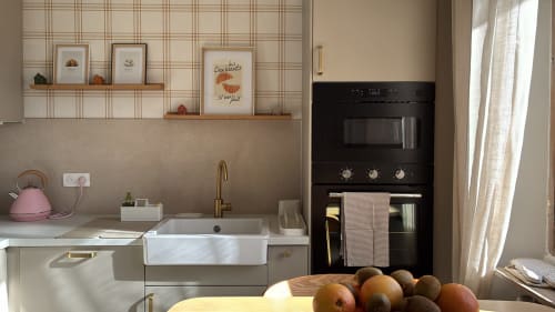 Cuisine moderne du gîte La Poterne à Épernay avec évier en marbre blanc, four noir et produits frais sur le plan de travail