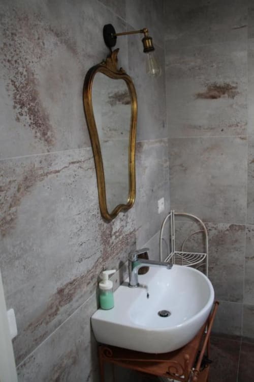 Lavandino rustico con rubinetteria in ottone e bacile bianco rotondo nell'appartamento di Marina di Grosseto