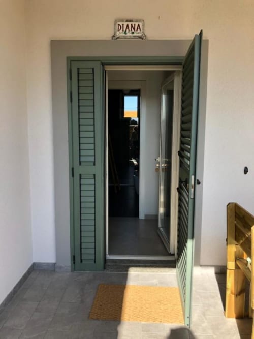 Ingresso con persiane verdi dell'appartamento Diana presso l'Agriturismo il Mandriolo, con accesso privato e vista sul giardino a Marina di
