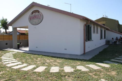 Agriturismo il Mandriolo, struttura rurale con muri bianchi, ingresso giardino e area patio in Italia