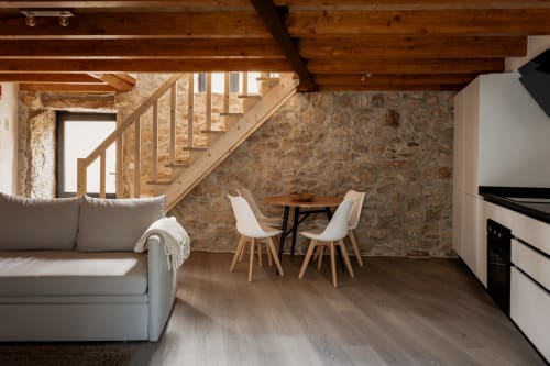Interior de loft moderno em Recantos D'Almerinda com paredes de pedra aparente, vigas de madeira, área de refeições e confortável sala de estar