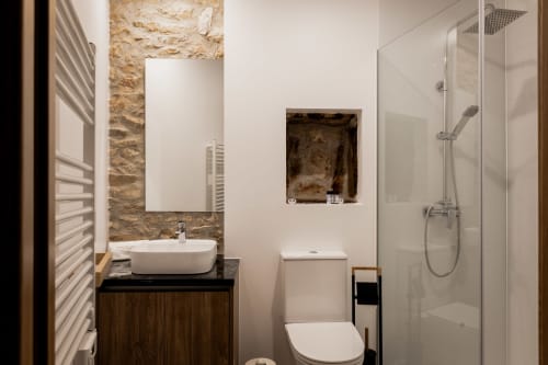 Banheiro moderno do hotel Recantos D'Almerinda em Pombal com parede de pedra aparente, cuba de sobrepor e chuveiro de vidro