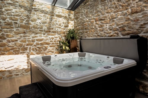 Luxuosa banheira de hidromassagem em spa com paredes de pedra do hotel Recantos d'Almerinda em Pombal, Portugal