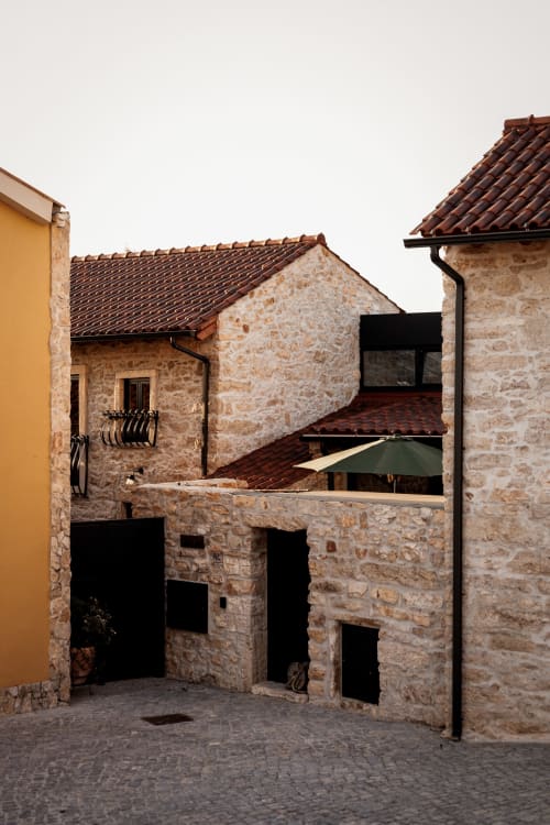 Pátio histórico de pedra do hotel Recantos D'Almerinda em Pombal, Portugal com telhados de barro