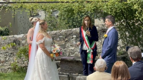 Wedding ceremony at Roseto del Drago, bride and groom with officiant in ivy-covered garden venue