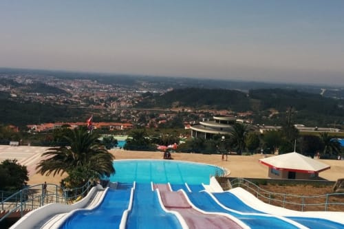 Escorregadores aquáticos na piscina do resort Recantos d'Almerinda em Pombal, Portugal, com vistas panorâmicas da cidade