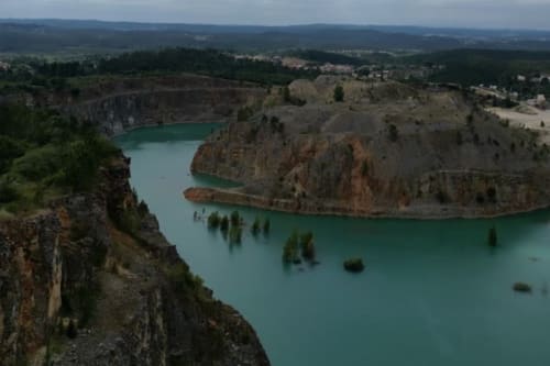 Lago de pedreira turquesa cercado por penhascos rochosos e floresta perto de Pombal, Portugal