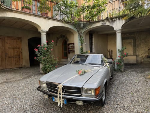 Classic convertible decorated for wedding at Roseto del Drago courtyard in Ponte In Valtellina