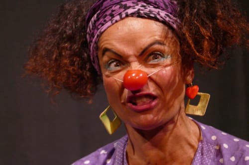 Playful clown performer with red nose and purple headband at Le Bacalan Bed & Breakfast in Mormoiron, France