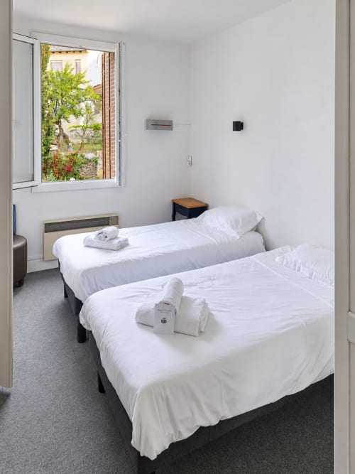 Chambre double avec draps blancs et vue sur le jardin à l'Hôtel du pont d'Estaing, Estaing, France