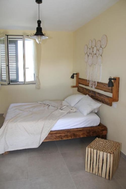 Camera accogliente all'Agriturismo il Mandriolo con letto in legno, biancheria bianca, lampada a sospensione e arredamento rustico