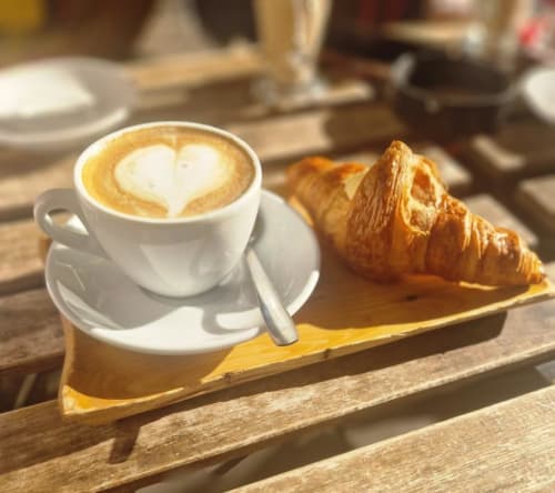 Cappuccino con latte art e cornetto alla colazione dell'Amor Rome Apartment a Roma