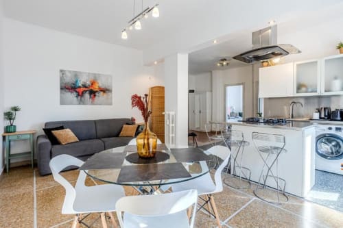 Moderno appartamento a Roma con cucina open space, zona pranzo e living con arredi contemporanei