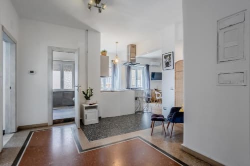 Moderno appartamento open-plan ad Amor Rome con pavimenti in cotto, cucina bianca con lampadari a sospensione e design minimalista