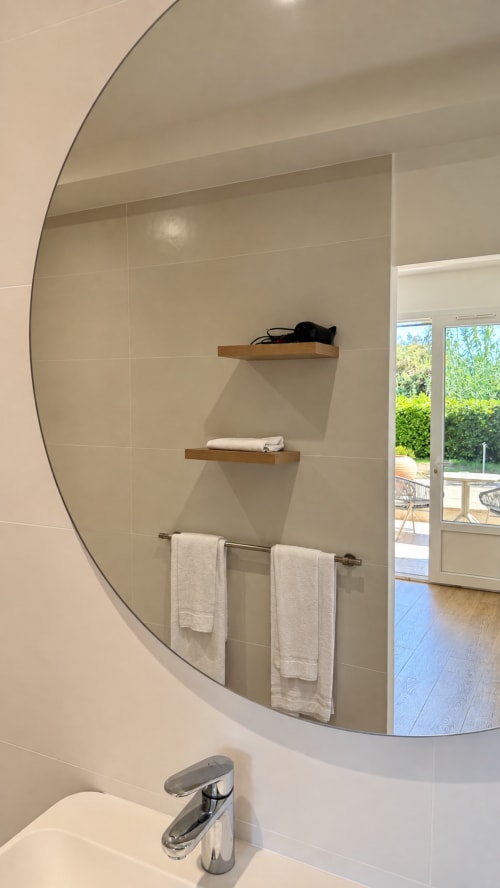 Miroir de salle de bain moderne avec étagères en bois à l'Hôtel Thalassa à Cargèse, porte-serviettes et lavabo