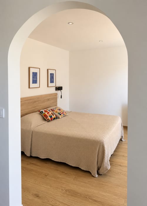 Chambre Supérieure à l'Hôtel Thalassa à Cargèse avec lit en bois, porte cintrée et décor moderne