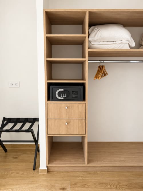 Meuble de rangement intégré en bois avec coffre-fort, étagères et tiroirs dans la Chambre Supérieure de l'Hôtel Thalassa, Cargèse