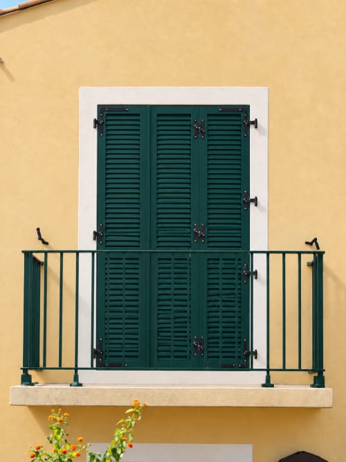Volets verts et balcon sur façade jaune de l'Hôtel Thalassa, Cargèse