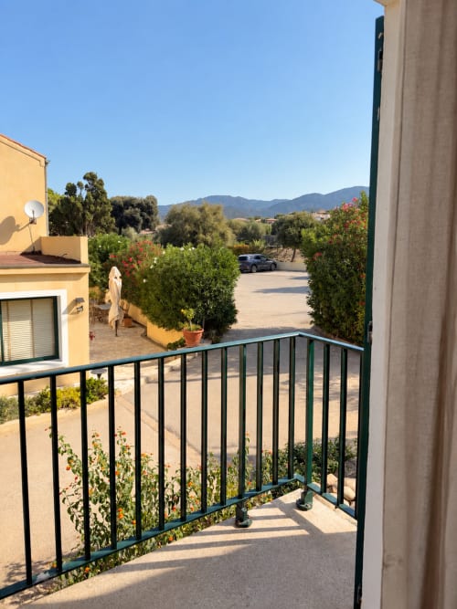 Vue depuis le balcon de la chambre Atypique de l'Hôtel Thalassa : montagnes de Cargèse, jardins et terrasse