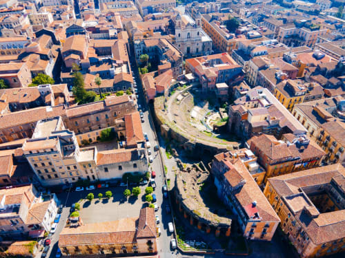 Vista aerea dei tetti in terracotta storica di Catania e i resti dell'antico anfiteatro romano