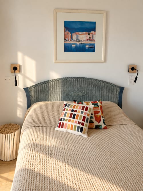 Chambre lumineuse à l'Hôtel Thalassa à Cargèse avec œuvres côtières, tête de lit tissée et coussins d'accent colorés