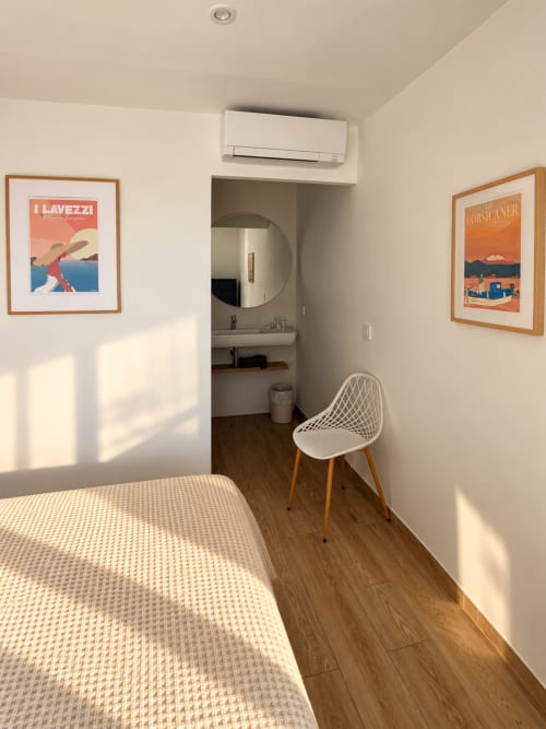 Chambre contemporaine à l'Hôtel Thalassa à Cargèse avec œuvres d'art côtier et mobilier minimaliste