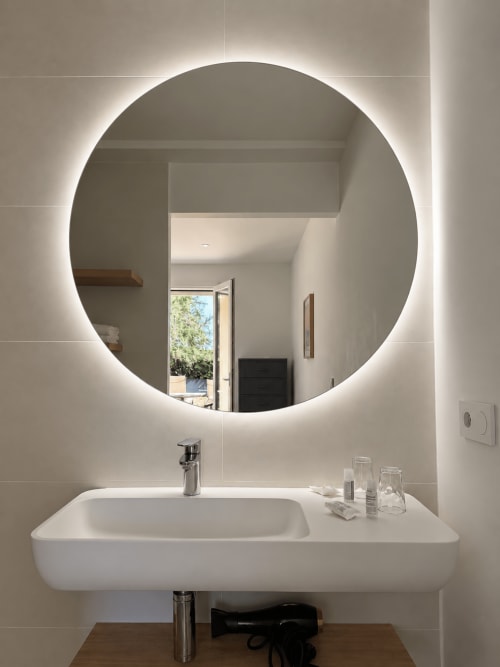Lavabo moderne et miroir circulaire rétroéclairé de l'Hôtel Thalassa à Cargèse